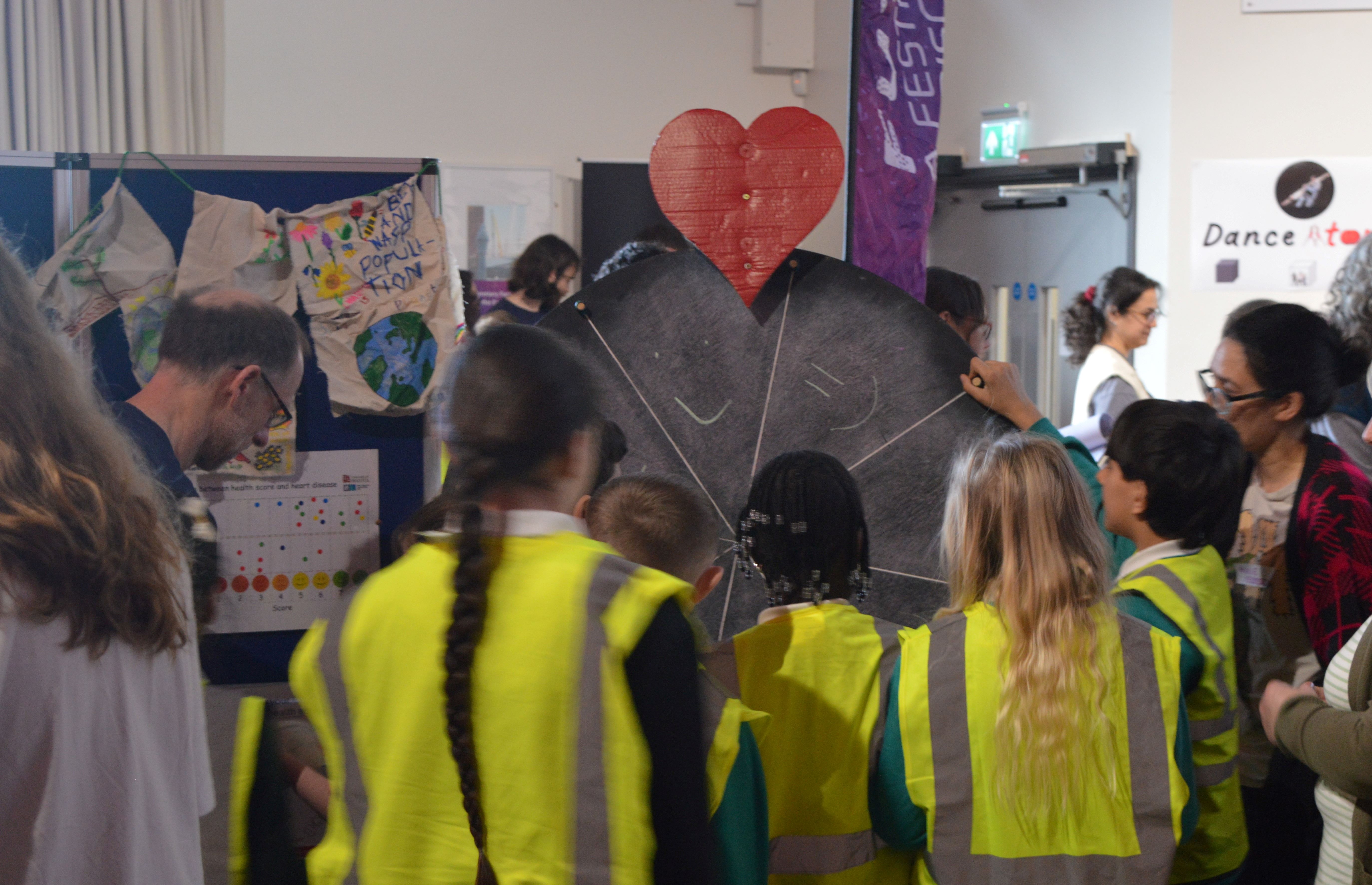 Children spinning a large wheel to see how different factors affect their overall health risk.